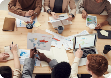Team collaboration around a table with documents and laptops